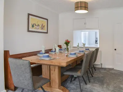 a dining room with a wooden table and chairs at Bryn Y Felin in Dyffryn
