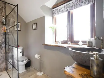 a bathroom with a large stone sink and a toilet at The Red House - Uk39234 in Minsterley