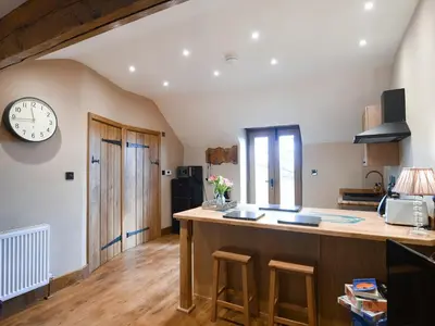 a kitchen with a counter and a clock on the wall at The Red House - Uk39234 in Minsterley