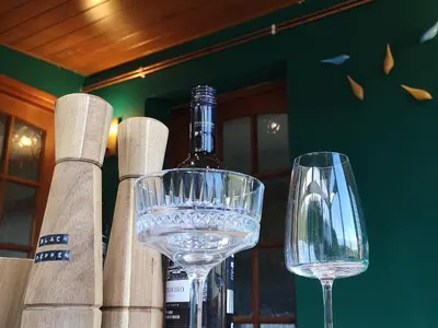 a bottle of wine and two wine glasses on a table at Hillside Cottage, countryside views near Llangollen in Corwen