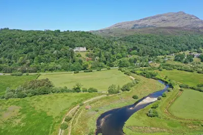 an aerial view of a river in a field at Ty Canol Maentwrog, Snowdonia Nr Zip World in Maentwrog