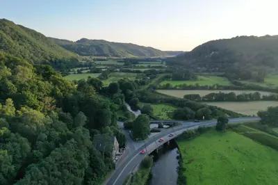 an aerial view of a bridge over a river at Ty Canol Maentwrog, Snowdonia Nr Zip World in Maentwrog