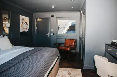 a bedroom with a bed and a chair and a window at Y Seler in Aberaeron