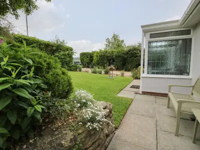 a garden with a bench next to a house at Roseland in Ludlow