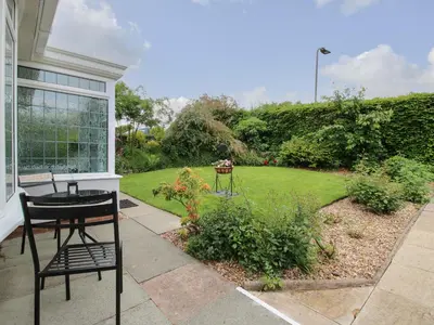 a patio with a table and chairs and a garden at Roseland in Ludlow