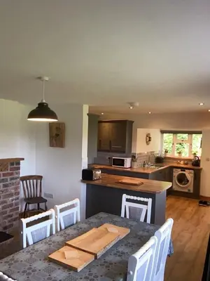 a kitchen with a table and chairs and a kitchen with a counter at 3 Bedroom Bungalow in Llanrhaeadr Ym in Oswestry