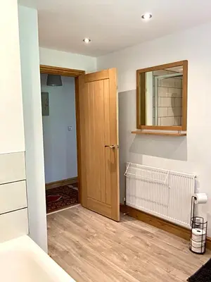 a room with a wooden door and a mirror at 3 Bedroom Bungalow in Llanrhaeadr Ym in Oswestry
