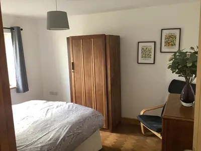 a bedroom with a bed and a wooden cabinet at 3 Bedroom Bungalow in Llanrhaeadr Ym in Oswestry
