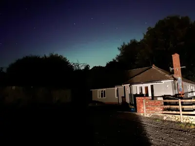 a small white house at night with the stars at 3 Bedroom Bungalow in Llanrhaeadr Ym in Oswestry