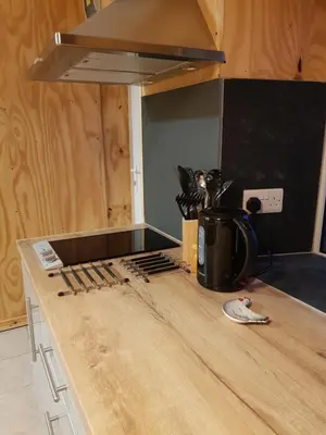 a kitchen with a counter with a stove top at Spacious heated Yurt with Hot tub, 5 mins to beach in Bow Street