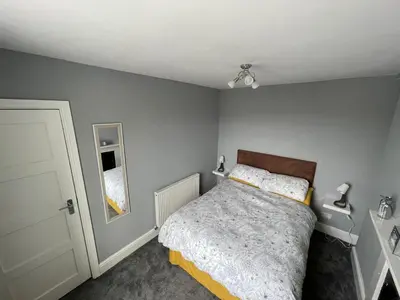 a small bedroom with a bed and a mirror at The Bala House in Bala
