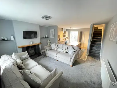 a living room with two couches and a staircase at The Bala House in Bala