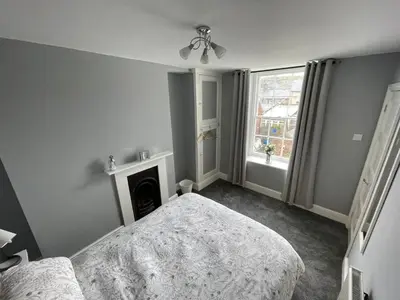 a bedroom with a bed and a fireplace and a window at The Bala House in Bala