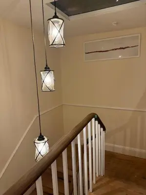 three lights hanging above a staircase in a house at Cae Nest Hall in Llanbedr