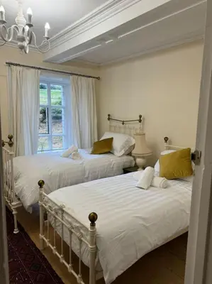 two beds in a bedroom with a window at Cae Nest Hall in Llanbedr