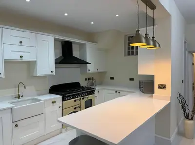 a kitchen with white cabinets and a white counter top at Cae Nest Hall in Llanbedr