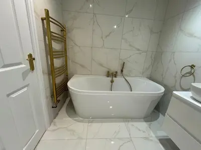 a white bathroom with a tub and a sink at Cae Nest Hall in Llanbedr