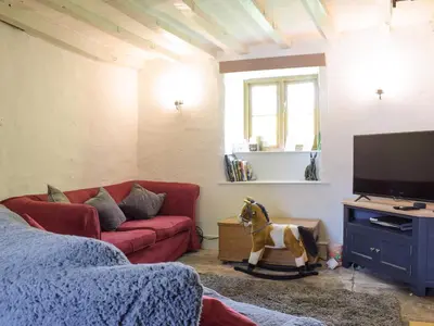 a living room with a couch and a horse statue at Lower Goytre Farmhouse in Llanvair Waterdine