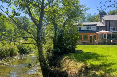 a house with a river in front of it at Marrington Mill in Chirbury
