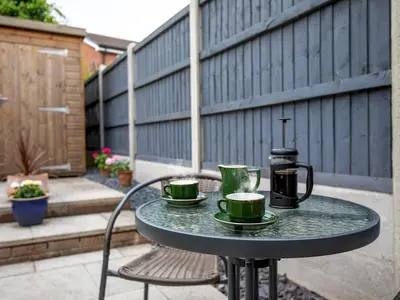 a table with two cups and a coffee maker on a patio at Cheerful and modern one bedroom home with parking - Pass the Keys in Shrewsbury