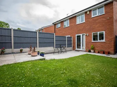 a brick house with a fence and a patio at Cheerful and modern one bedroom home with parking - Pass the Keys in Shrewsbury