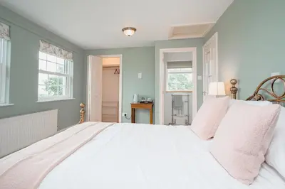 a large white bed in a room with windows at The Green Door Vegan B&B in Llanon