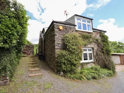 an old stone house with a window on the side of it at Bodowen Coach House in Barmouth