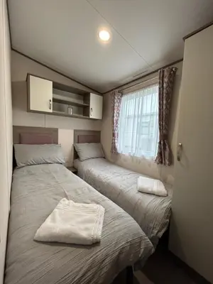 two beds in a small room with a window at Delightful 2 bedroom Caravan, Pencnwc, New Quay in Cross Inn