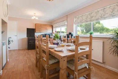 a kitchen and dining room with a wooden table and chairs at 3 Bed in Aberaeron oc-bow330 in Ciliau-Aeron