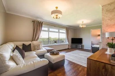 a living room with a white couch and a large window at 3 Bed in Aberaeron oc-bow330 in Ciliau-Aeron