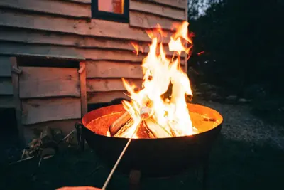 a fire in a pot in front of a building at Empress En Suite Wagon in Arthog