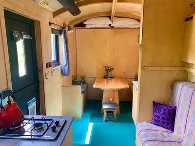 a tiny house with a table and a stove in it at Empress En Suite Wagon in Arthog