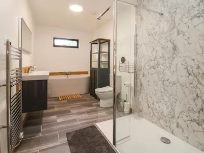 a bathroom with a shower and a toilet and a sink at No1 The Lodge in Bishops Castle