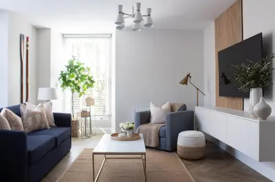 a living room with a blue couch and a table at John Lewis Apartment in Aberaeron
