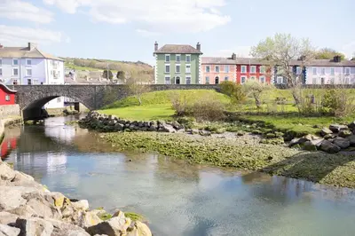 a bridge over a river with buildings in the background at John Lewis Apartment in Aberaeron