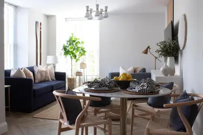 a living room with a table and a blue couch at John Lewis Apartment in Aberaeron