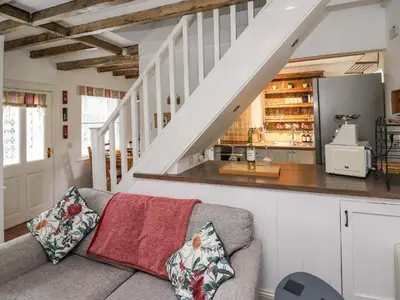 a living room with a couch and a staircase at Bryniau Bychain Cottage in Machynlleth