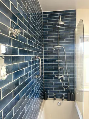 a blue tiled bathroom with a tub and a shower at Old Street Terrace in Ludlow