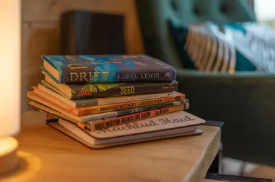 a stack of books sitting on a table at Blaenplwyf Shire Pods in Lampeter