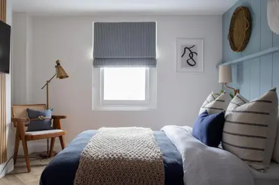 a bedroom with a blue bed and a window at Salthouse apartment in Aberaeron