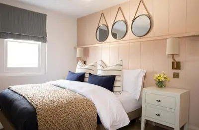 a bedroom with a bed with two mirrors on the wall at Salthouse apartment in Aberaeron
