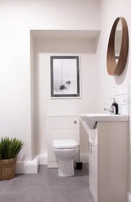 a white bathroom with a toilet and a sink at Salthouse apartment in Aberaeron