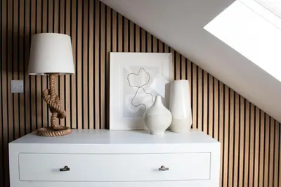 a white dresser with a lamp and vases on it at Morahan apartment in Aberaeron