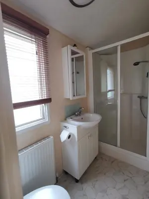 a bathroom with a toilet and a sink and a shower at Sea and Mountain view Sunbeach Holiday Snowdonia in Llwyngwril