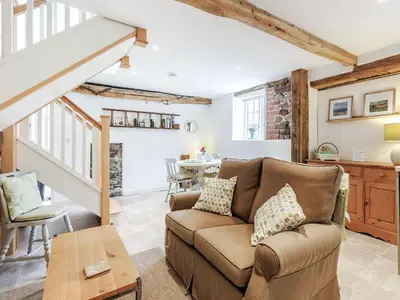 a living room with a couch and a table at The Old Milking Parlour in Wentnor