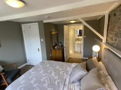 a bedroom with a bed and a hallway with a bathroom at Tom's of Tregaron in Tregaron