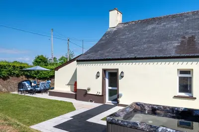 a white house with a hot tub in the yard at 2 Bed in Tregaron oc-bow289 in Tregaron