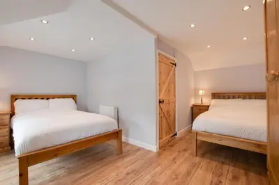 two beds in a room with white walls and wooden floors at 2 Bed in Tregaron oc-bow289 in Tregaron