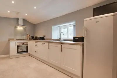 a kitchen with white cabinets and a sink and a refrigerator at 2 Bed in Tregaron oc-bow289 in Tregaron