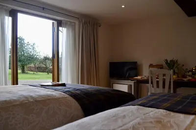 a bedroom with a bed and a desk and a window at The Cedars Ludlow in Lane to Richards Castle